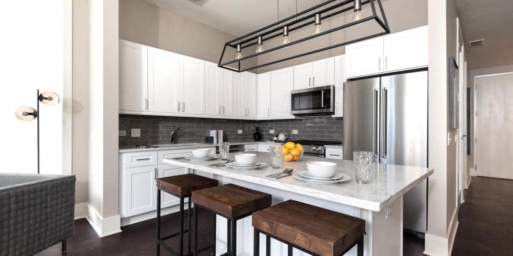 a kitchen with an island and three stools  at Clark 2050, Chicago, Illinois