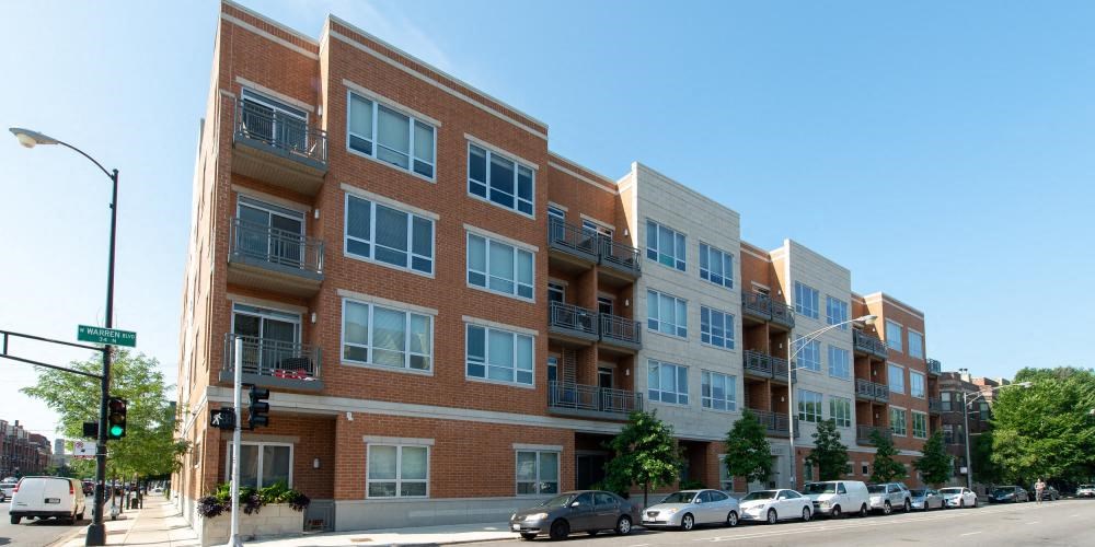 a large brick building with cars parked in front of it  at Tripp 4321, Chicago, 60641