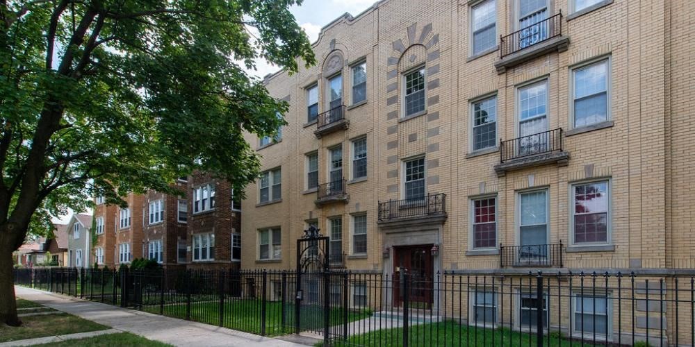 a row of brick apartment buildings on a sidewalk at Christiana 4954, Chicago, IL 60625