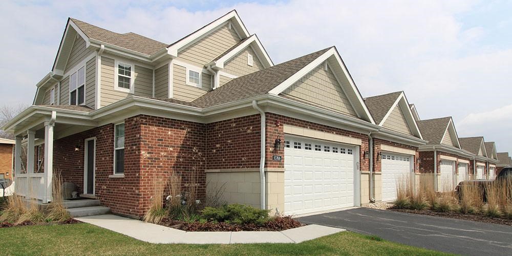 a brick house with a white garage door at Countryside Townhomes, Countryside Illinois