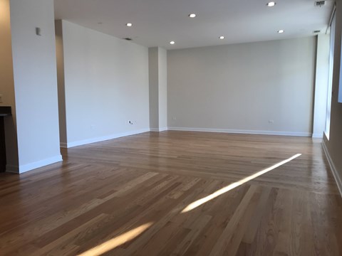 A room with wooden flooring and white walls.
