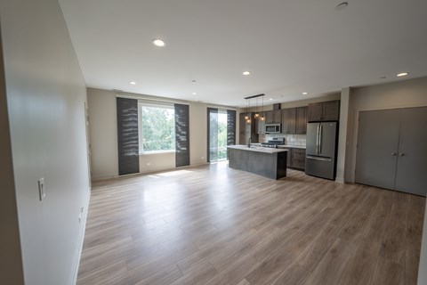 A spacious kitchen and living room with wooden flooring and modern appliances.