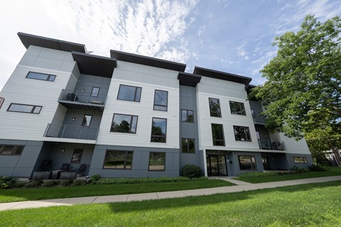 A modern apartment building with balconies and large windows.