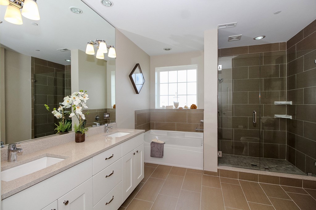 a bathroom with two sinks and a tub and a shower