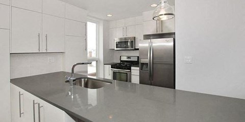 a kitchen with a sink and a stainless steel refrigerator
