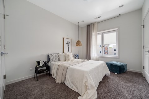 A bedroom with a large bed and a window.