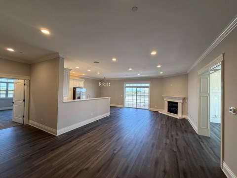 A spacious living room with hardwood floors and a fireplace.