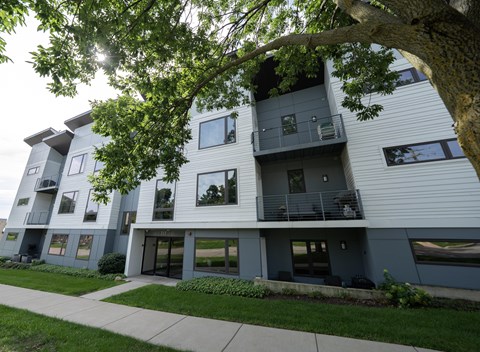 A modern apartment building with balconies and large windows.