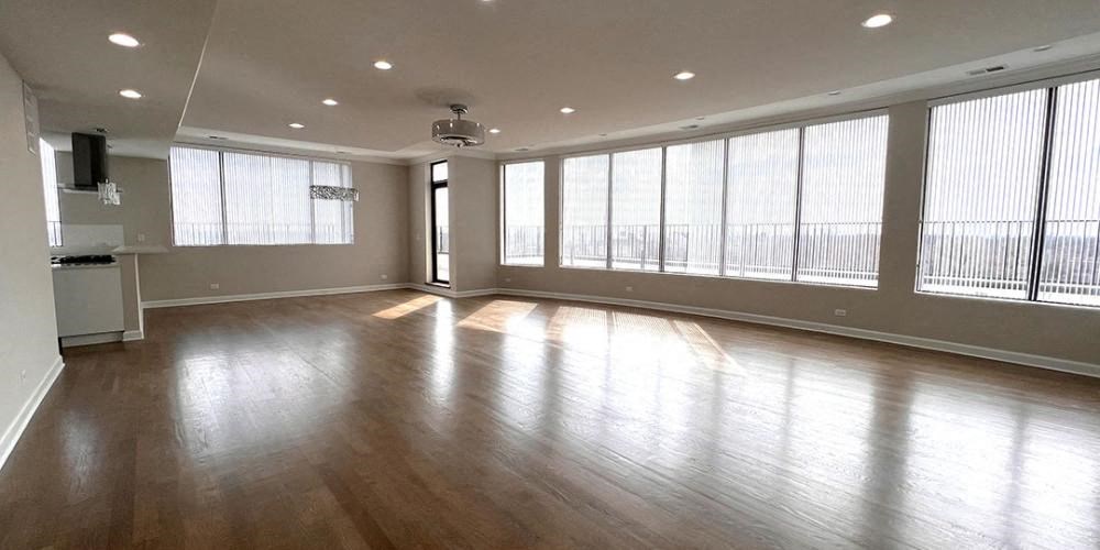 an empty living room with wood floors and large windows  at Lavergne 4810, Illinois