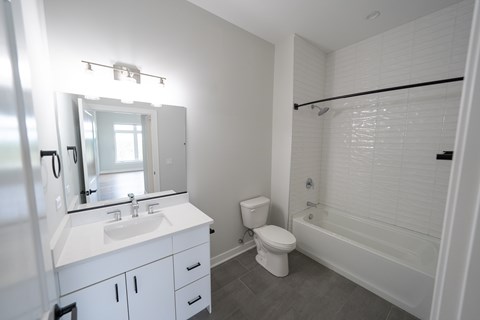 A white bathroom with a toilet, sink, and bathtub.