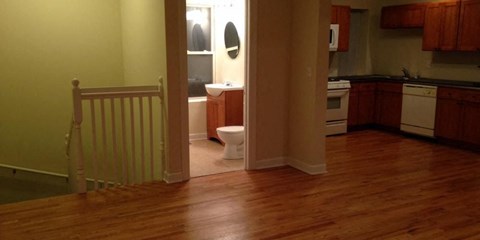 a kitchen with a table and a bathroom with a toilet