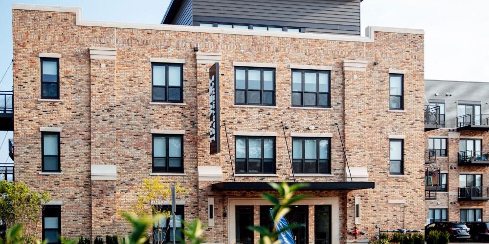 a large brick building with a flag on the front at Barrington 101, Barrington, IL
