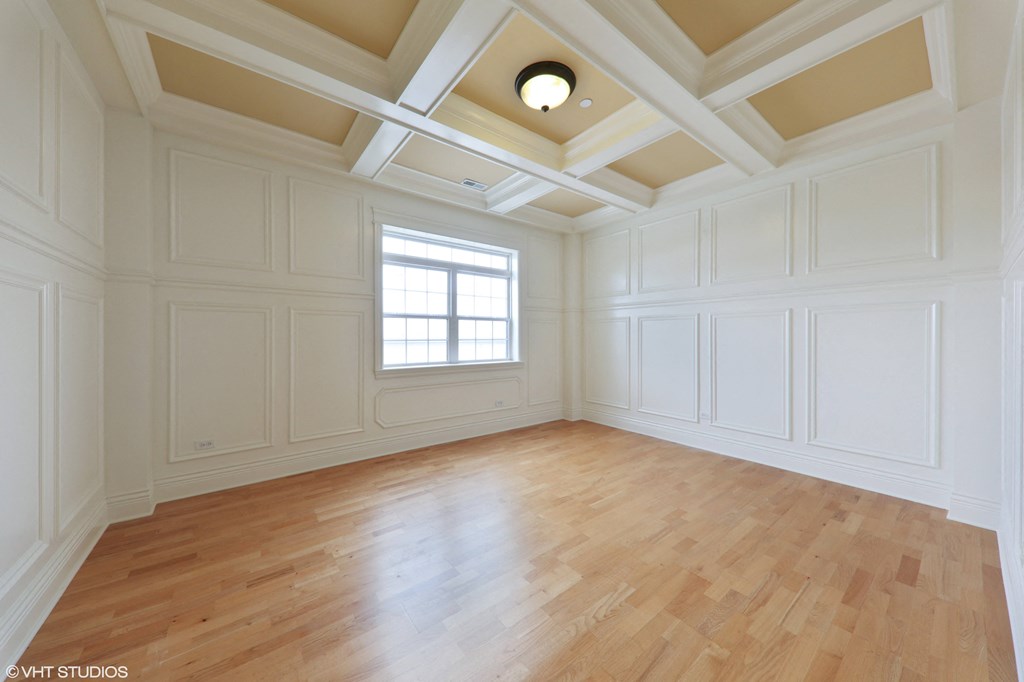 an empty living room with wood floors and white walls and a window