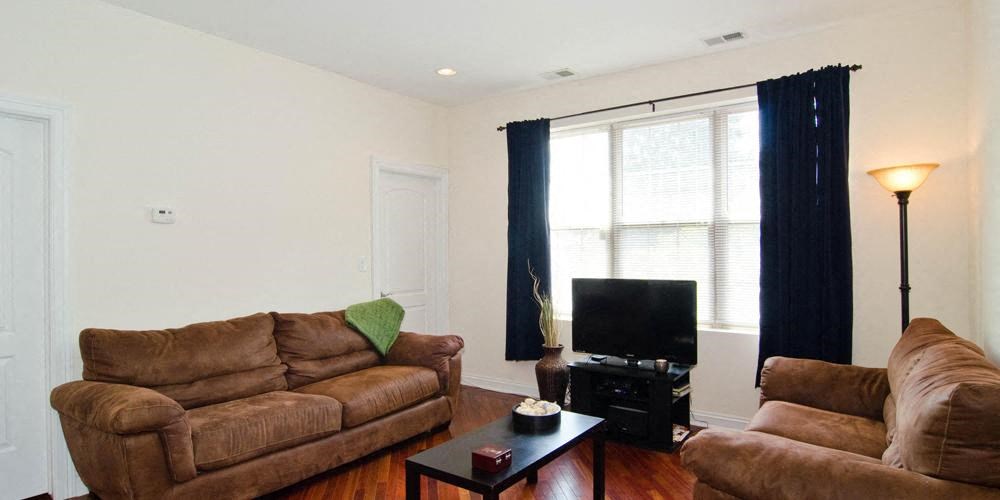 a living room with two couches and a television at Tripp 4321, Chicago