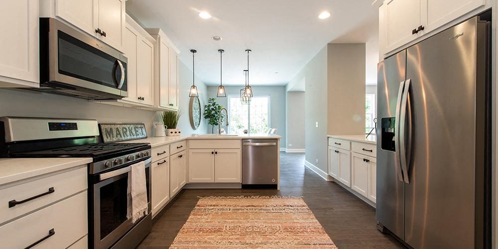 a kitchen with stainless steel appliances and white cabinets at Countryside Townhomes, Illinois