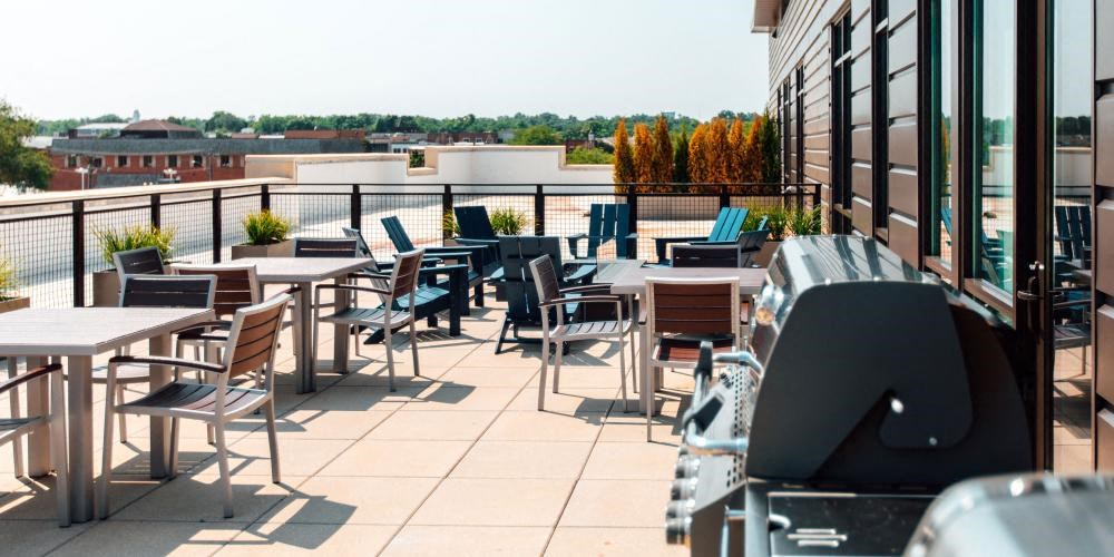 a patio with tables and chairs on the roof of a building at Barrington 101, Barrington, IL 60010