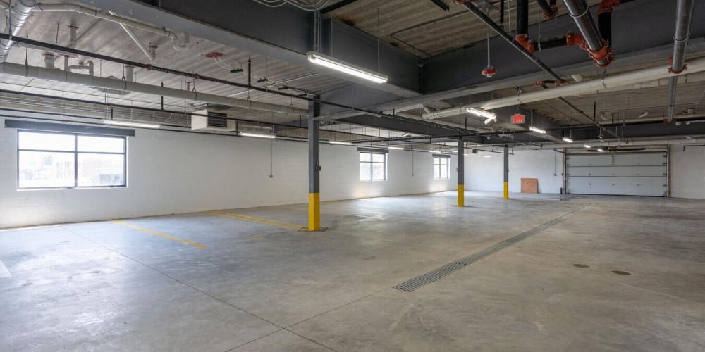 a large empty parking garage with white walls and yellow poles  at Highwood 246, Highwood, 60040