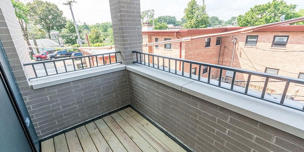 a balcony with a brick wall and a wooden floor at Wilmette 1121, Illinois