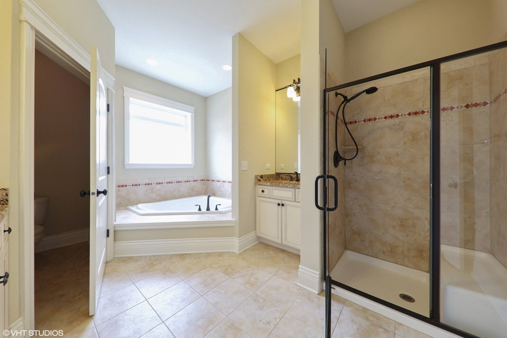 a bathroom with a shower and a tub and a sink