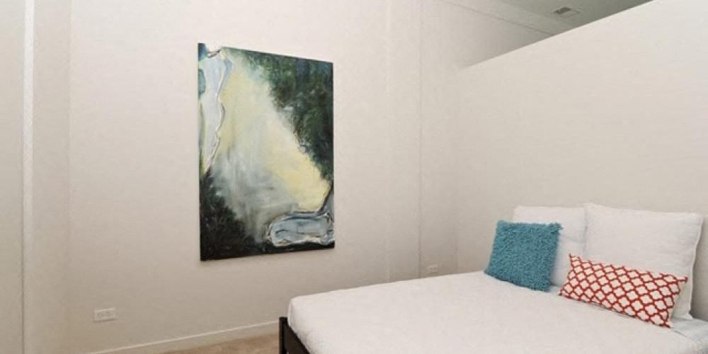 a bedroom with a bed and two paintings on the wall  at Fullerton 1540, Chicago