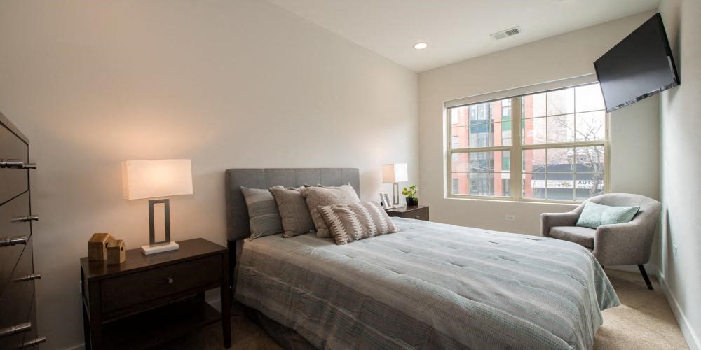 a bedroom with a bed and a chair and a tv  at Kedzie 4447, Chicago