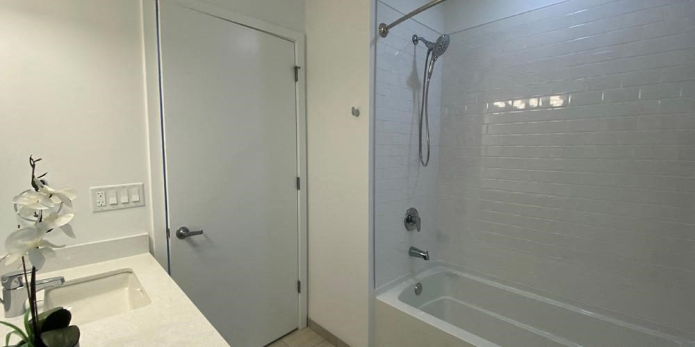 a white bathroom with a shower and a sink at Highwood 546, Highwood