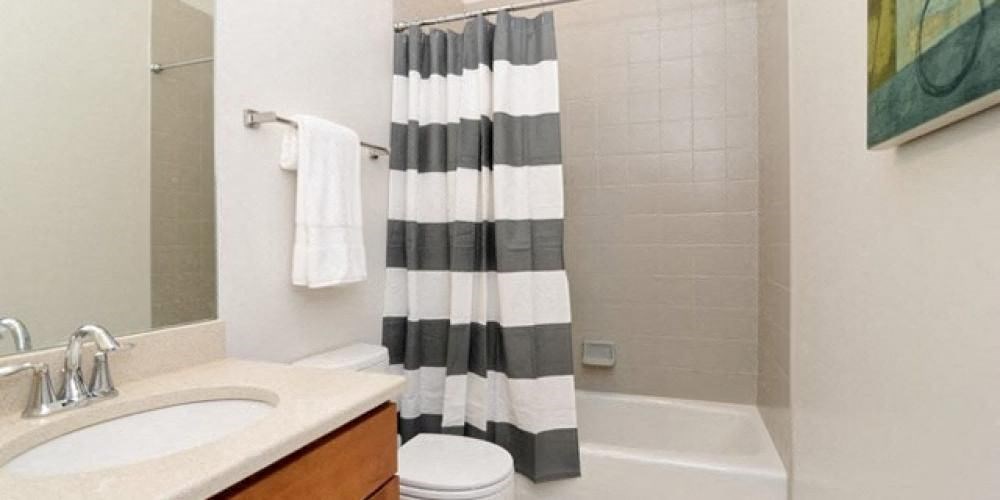 a bathroom with a shower curtain and a sink and a toilet  at Fullerton 1540, Chicago, IL