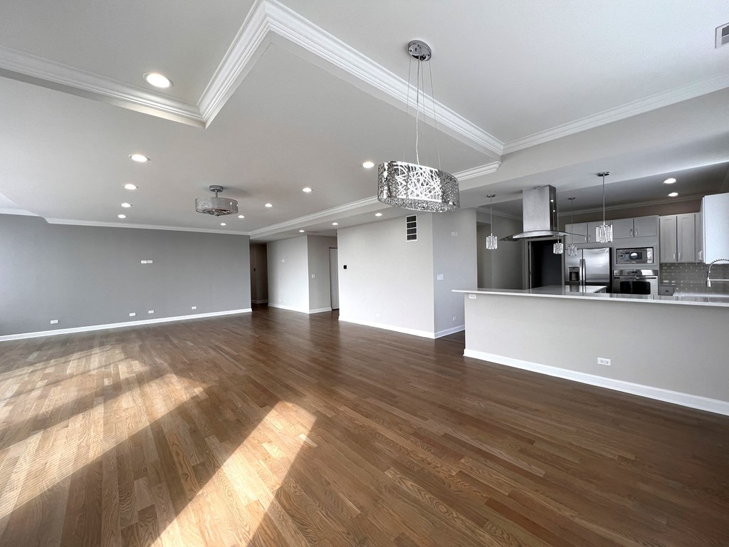 a renovated living room and kitchen with wood floors and white walls