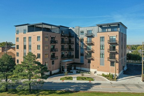 a brick apartment building with balconies and a sidewalk