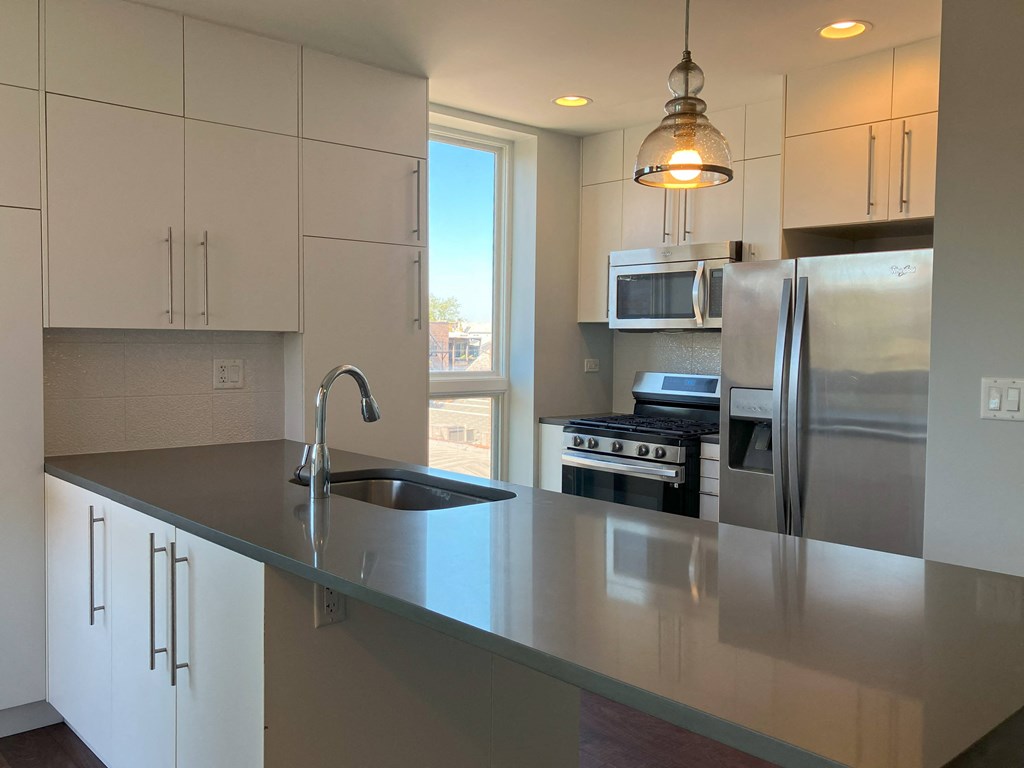 a kitchen with a large island and stainless steel appliances