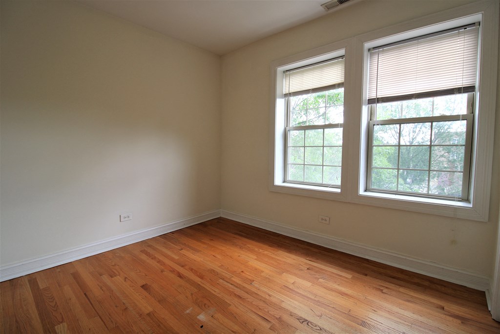 an empty room with wooden floors and two windows at Christiana 4954, Chicago, IL