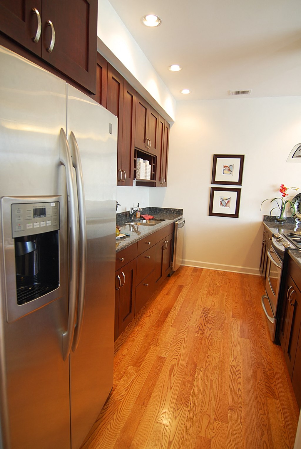 a kitchen with stainless steel appliances and wooden floors