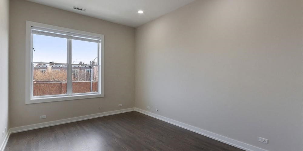 an empty living room with a window and wooden floors  at Elston 3434, Chicago, Illinois