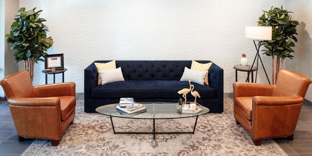 a living room with a blue couch and a glass table at Barrington 101, Chicago