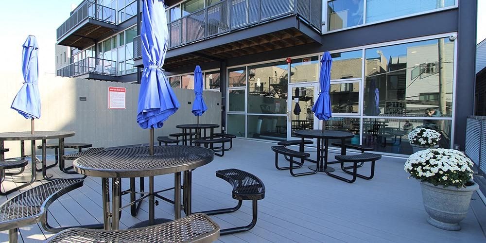 an outside patio with tables and chairs and umbrellas  at Fullerton 1540, Chicago