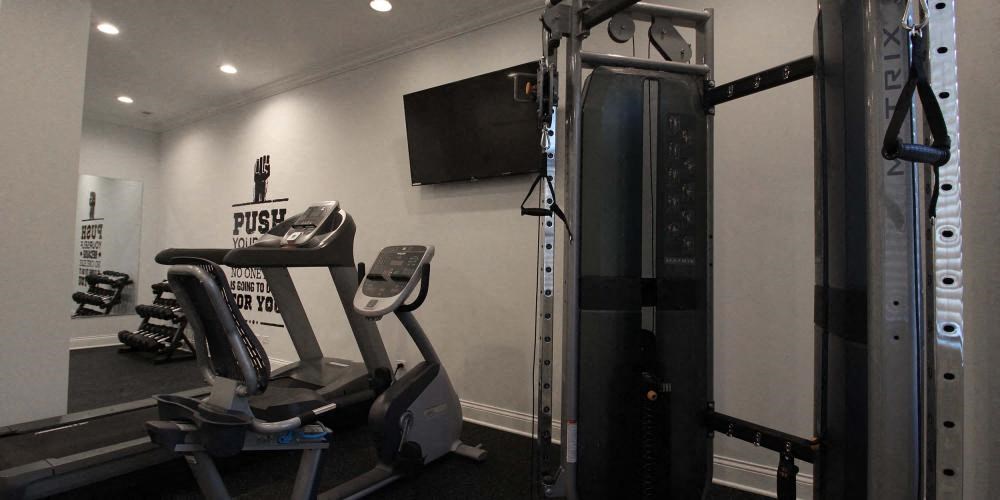 a gym with weights and a tv on the wall at Tripp 4321, Chicago, 60641