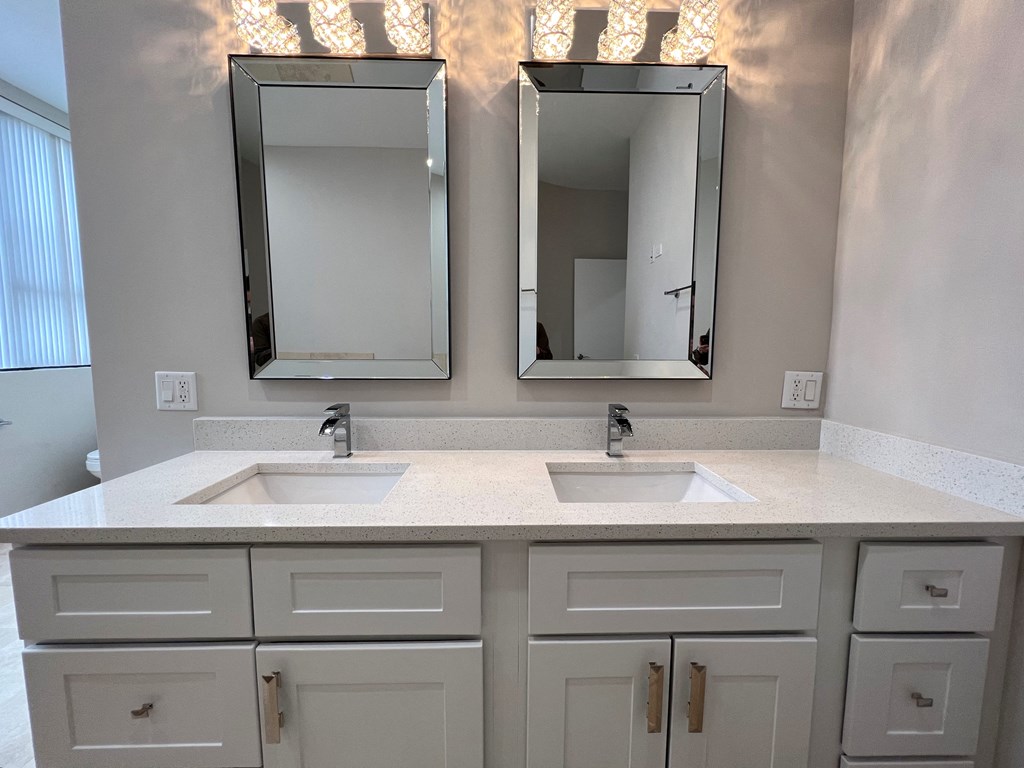 a bathroom with two sinks and two mirrors