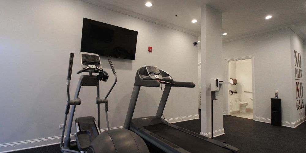 a gym with two machines and a tv on the wall at Tripp 4321, Chicago, 60641