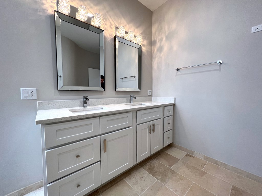 a bathroom with two sinks and two mirrors