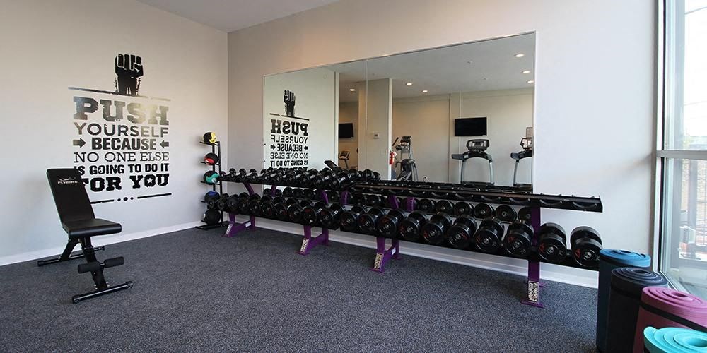 a gym with a large mirror and a row of dumbbells  at Fullerton 1540, Illinois