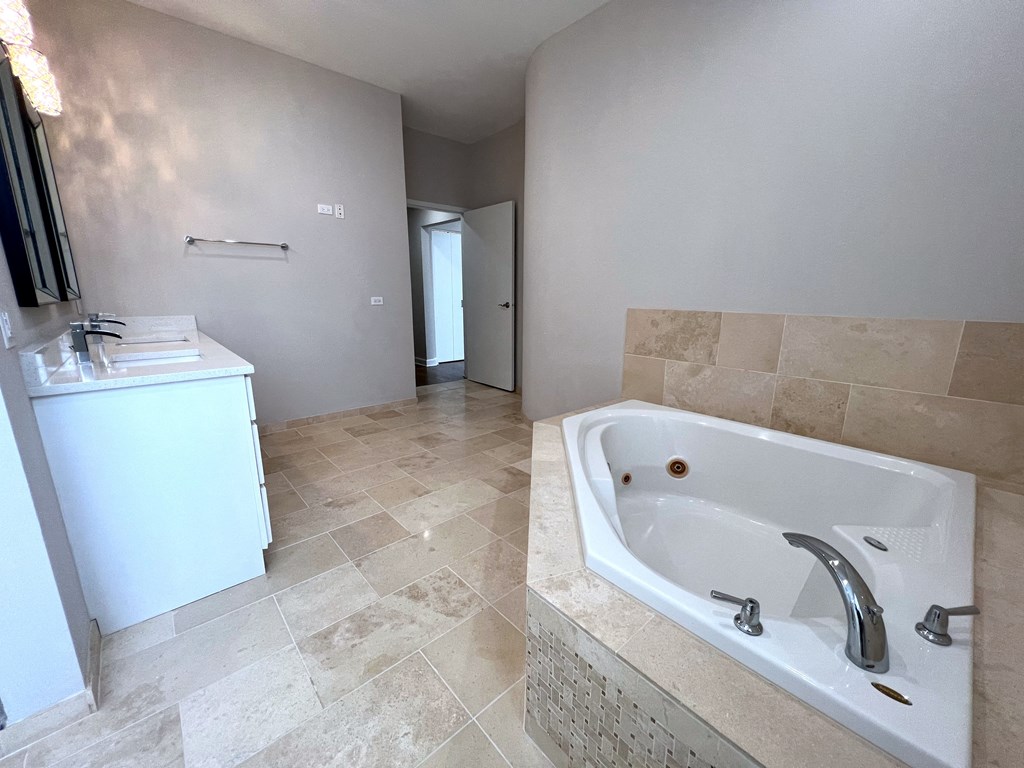 a bathroom with a large tub and a sink