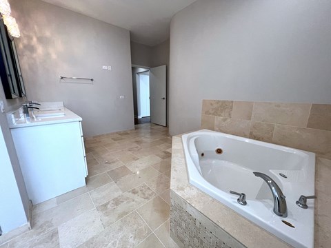a bathroom with a large tub and a sink