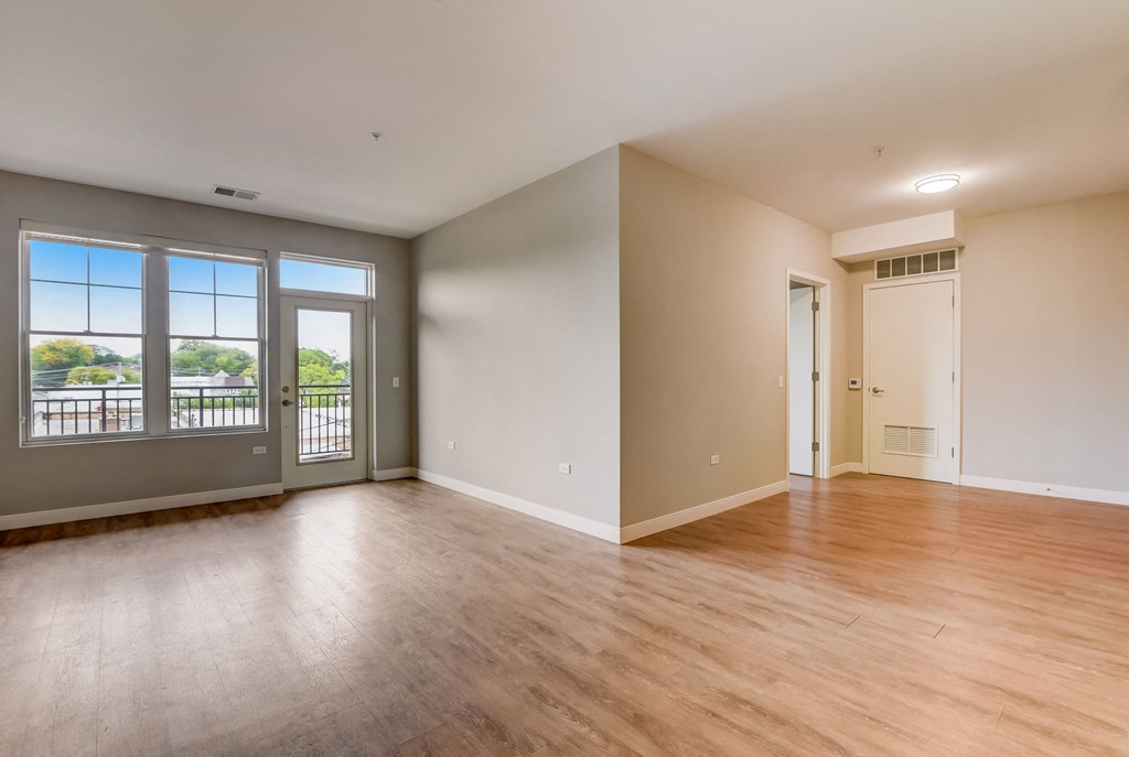 an empty living room with wood floors and a door to a balcony at Clarendon Hills 229, Clarendon Illinois