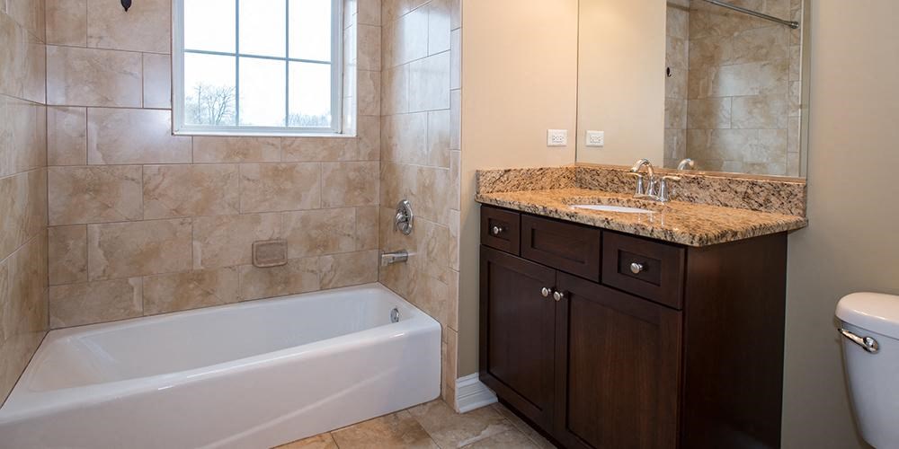 a bathroom with a tub and a sink and a mirror  at Countryside 10765, Countryside