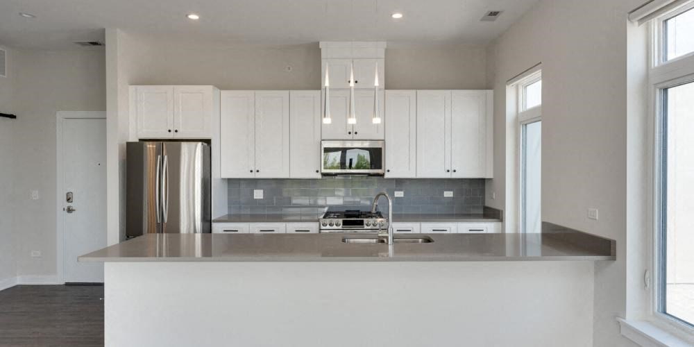 a white kitchen with white cabinets and a stainless steel refrigerator  at Highwood 246, Highwood, IL