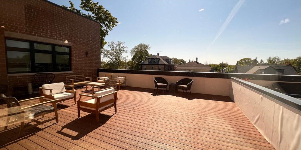 a wooden deck with chairs on top of a building at Highwood 440, Highwood Illinois