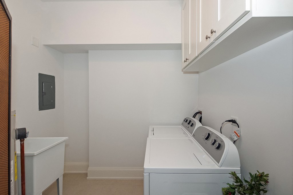 a laundry room with a washer and dryer and a sink
