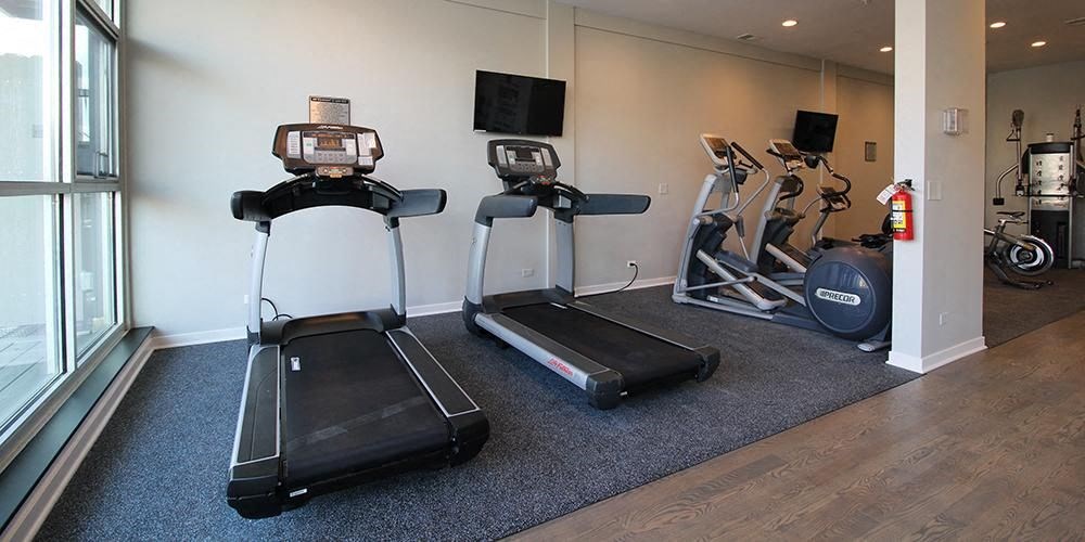 a group of exercise equipment in a room with a window  at Fullerton 1540, Illinois