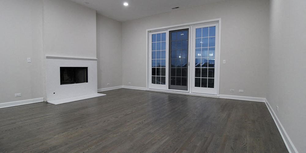 an empty living room with a fireplace and windows  at Elston 3434, Chicago, IL