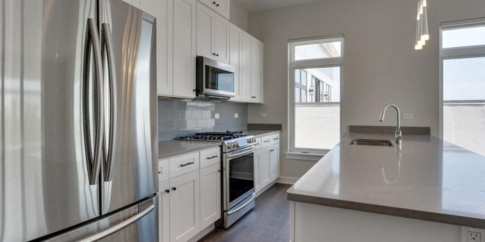 a kitchen with white cabinets and stainless steel appliances  at Highwood 246, Highwood